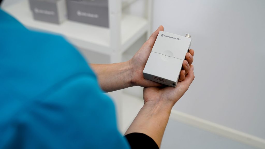custo screen 300 wird von medizinischer Fachkraft in der Hand gehalten