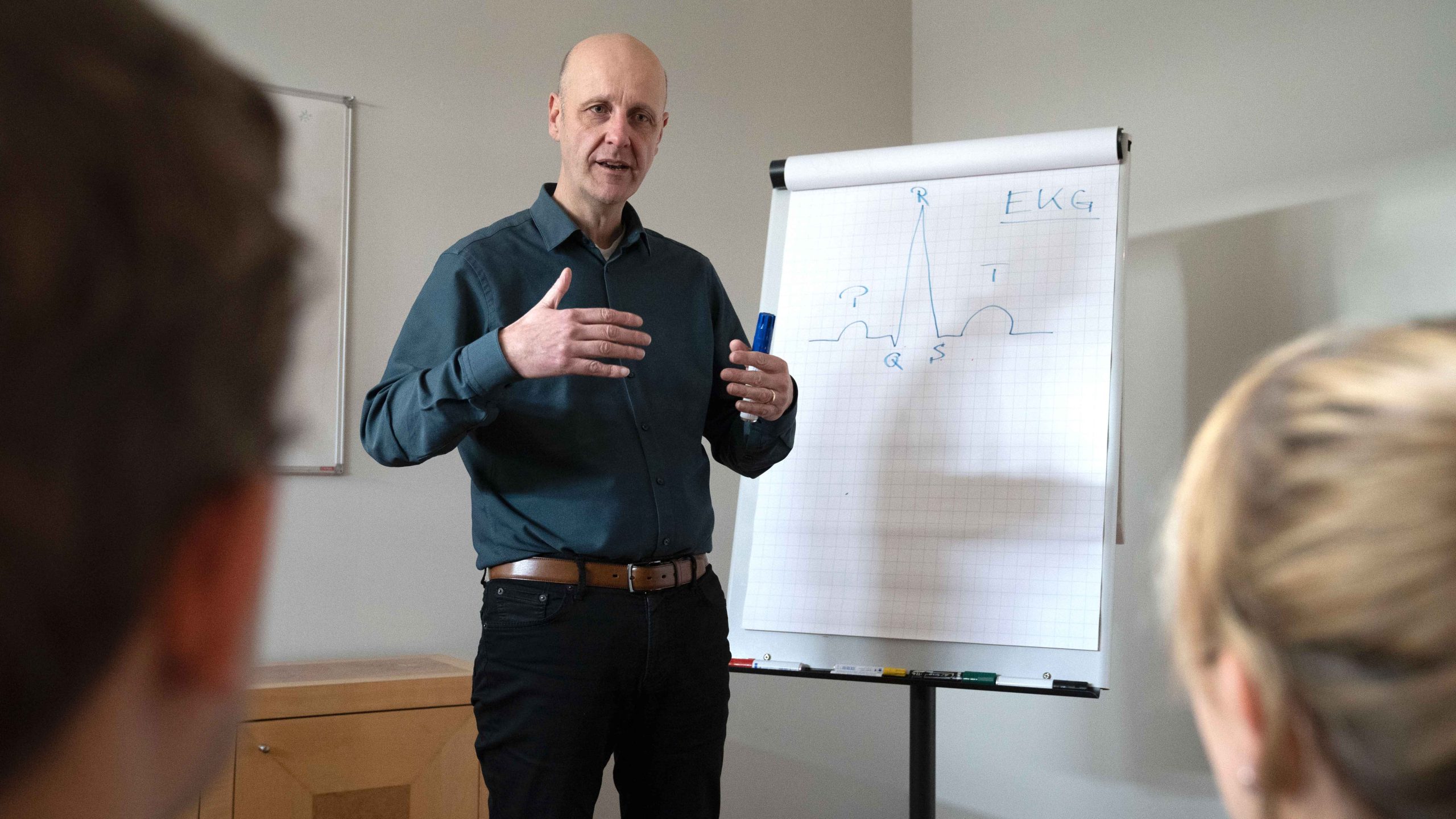 Kardiologie-Training: Arzt erklärt EKG an Flipchart vor interessierten Zuhörern
