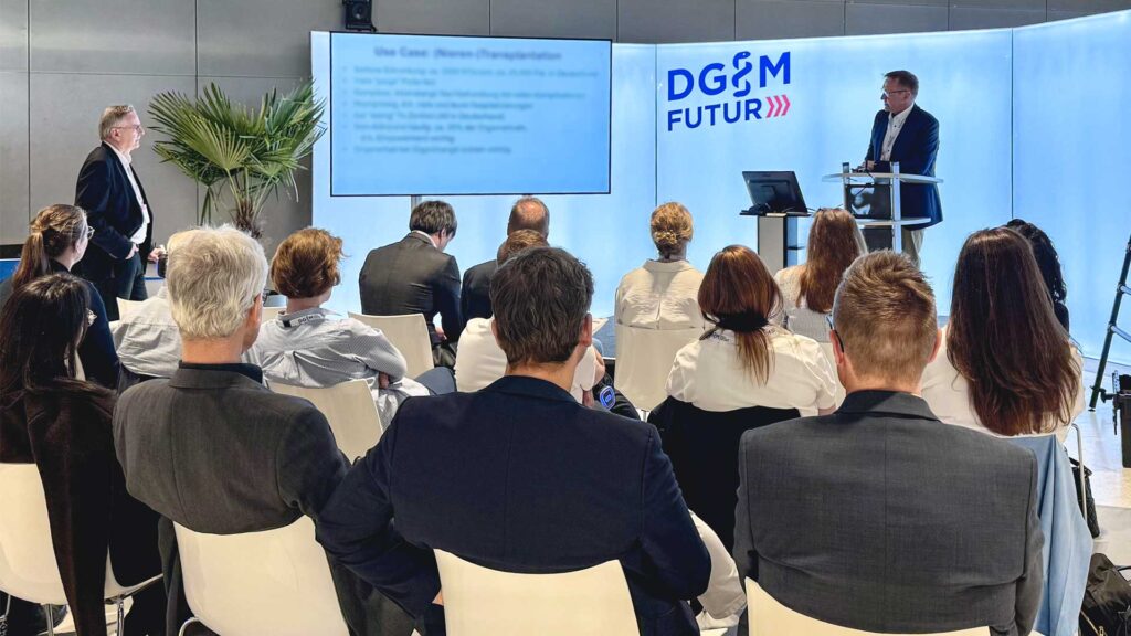 Conferenza al congresso DGIM, pubblico fotografato di spalle con vista sul palco